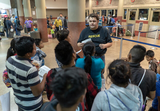IRC staff member helping Central Americans find their buses 