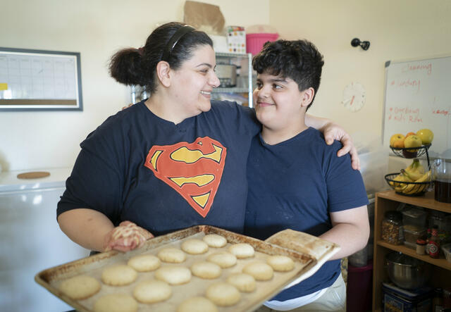 Taghreed and her 10-year-old son Yousif hold a tray of cardamom cookies they baked.