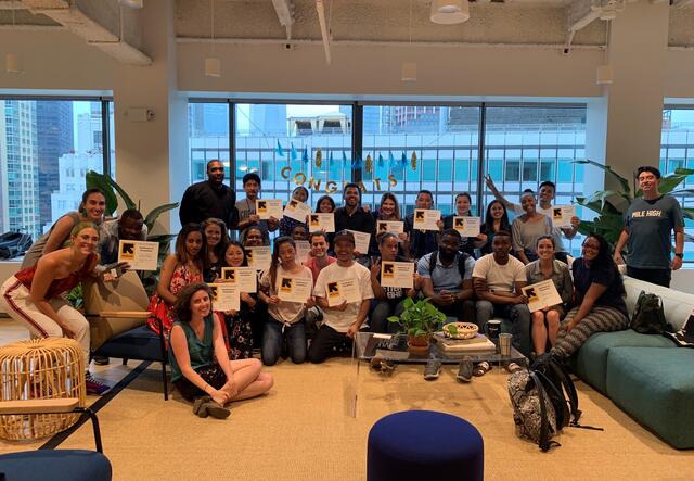 very large group of WeWork training candidates posing with their graduation diplomas.