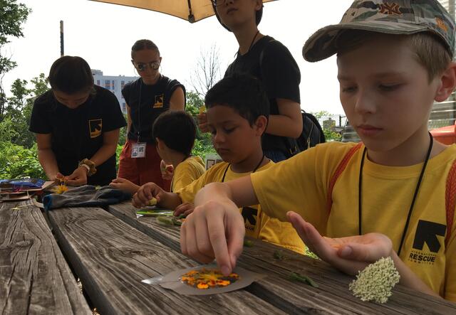 a group of children crafting in the garden table with flowers