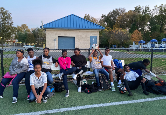 students gathered on a park bench, relaxing after a game