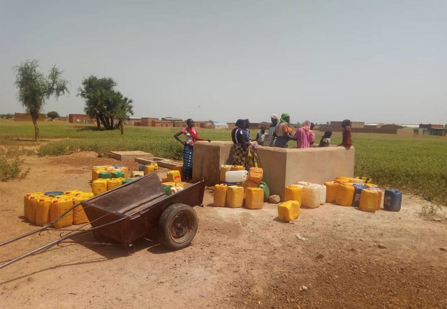 People gathered at an -supported water station near Djibo, in northern Burkina Faso. 