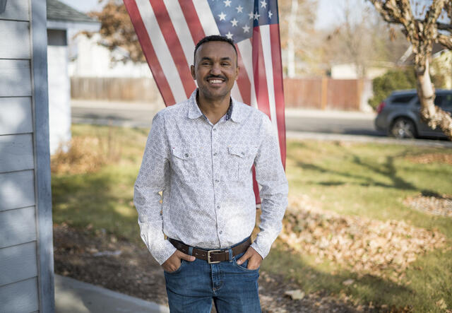 Tecle, an IRC staff member, stands outside his home in Boise, Idaho