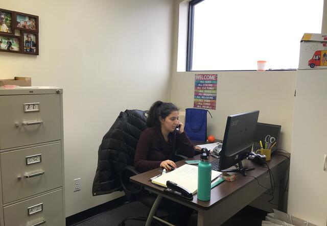 Heather making calls in her office, to support clients