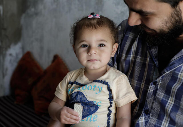 A 32-year-old man holds his 1 1/2 year-old daughter in Armanaz town in western Idlib. 