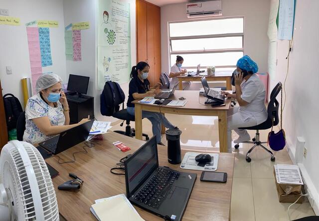 Doctors and nurses sit at a table and take phone calls at the IRCs telemedicine clinic in Cúcuta, Colombia. 