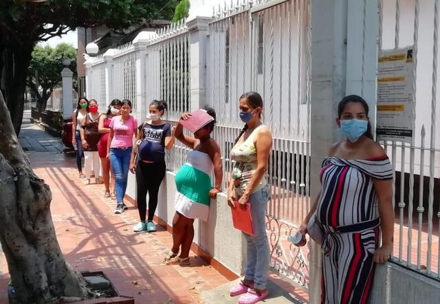 Pregnant woman stand outside six feet apart from one another outside the IRC's maternal health clinic in Cúcuta, Colombia.