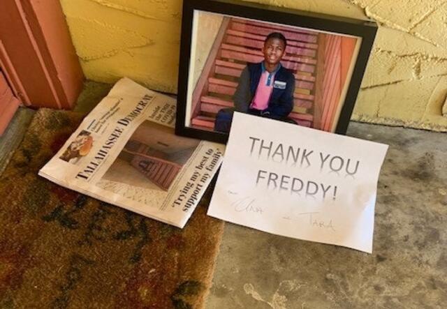 A newspaper with a picture of a young man on the front page, a framed copy of that photo and a sign that says "Thank You Freddy" are left on a doormat outside Freddys home.