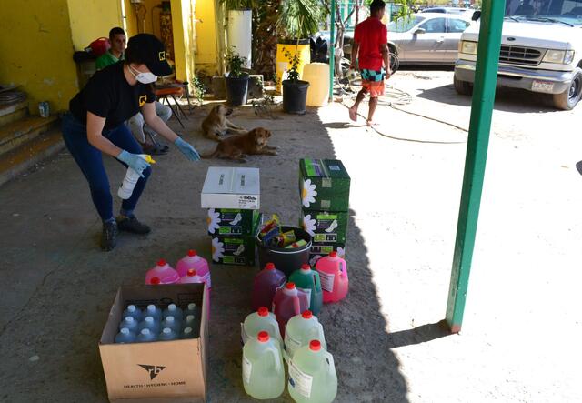 An IRC staff member stands above buckets of cleaning supplies to be delivered to shelters in Ciudad Juárez, Mexico. 