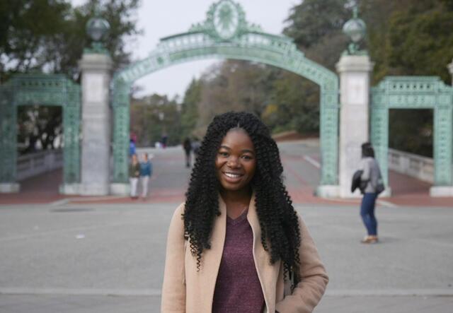 Torbertha Torbor stands outside the front gate at the University of California at Berkeley