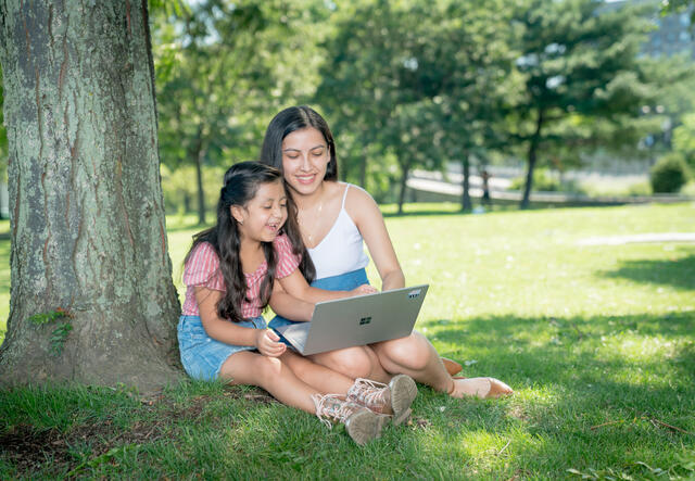 NYSA student and peer mentor learning using a laptop in the park