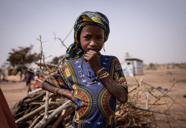 A young girl poses for a portrait in camp for internally displaced people in Barsalogho, Burkina Faso.