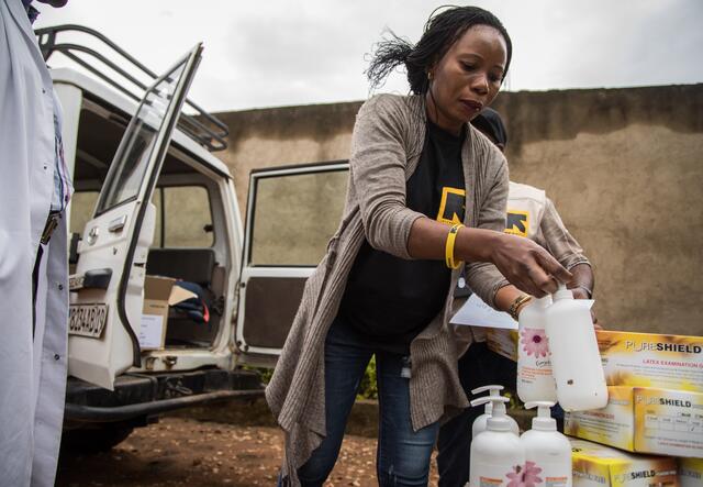 An IRC doctor unloads hand sanitizer and other supplies for a clinic treating Ebola patients.