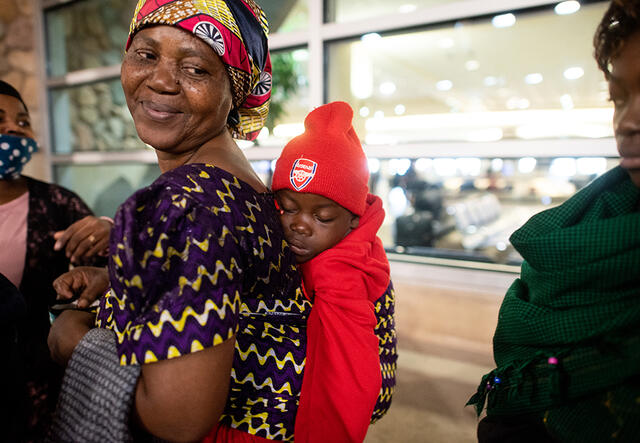 Wanyema smiles with a baby on her back at the Boise Airport