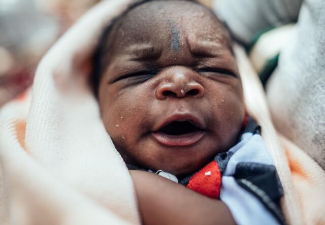 A Nigerian baby swaddled in a blanket