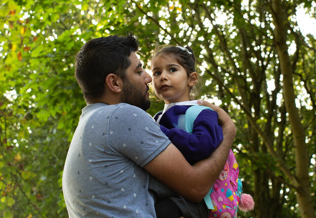 Maasom holds his 4-year-old daughter Nasrin on her first day of preschool.