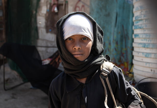 A 10-year-old girl looks at the camera near her home in a camp for internally displaced people in Yemen. 