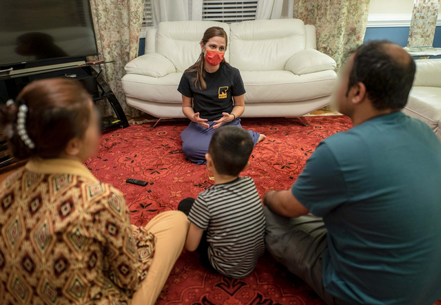 Newly arrived family gathers in their living room. 