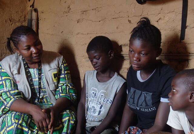 Orphans Anita, Franck, and Freddy talking with IRC worker