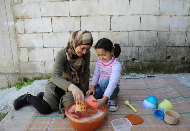 Ahlam and Sadal do an activity together while washing dishes 