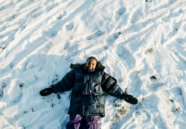 An 8-year-old SOmali boy makes a snow angel.
