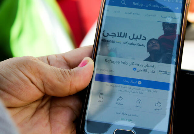 Close-up of a phone a woman is using to access Refugee.Info 
