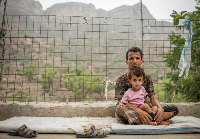 Abdul Ghafar sits with his young son, Abdullah