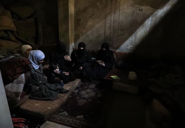 Um Sulieman, 56, and her family huddle together in the dark below the streets of Eastern Ghouta while planes passed overhead. 