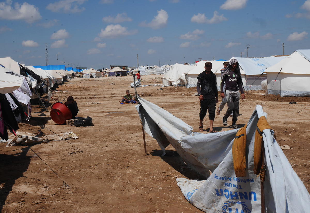 Iraqi refugees walk along a row of tents in Al Hol camp in northeast Syria.