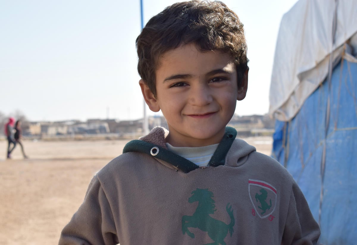 The three-year-old grandson of Yazidi couple Suleiman and Khabshe, outside a tent at Newroz refugee camp