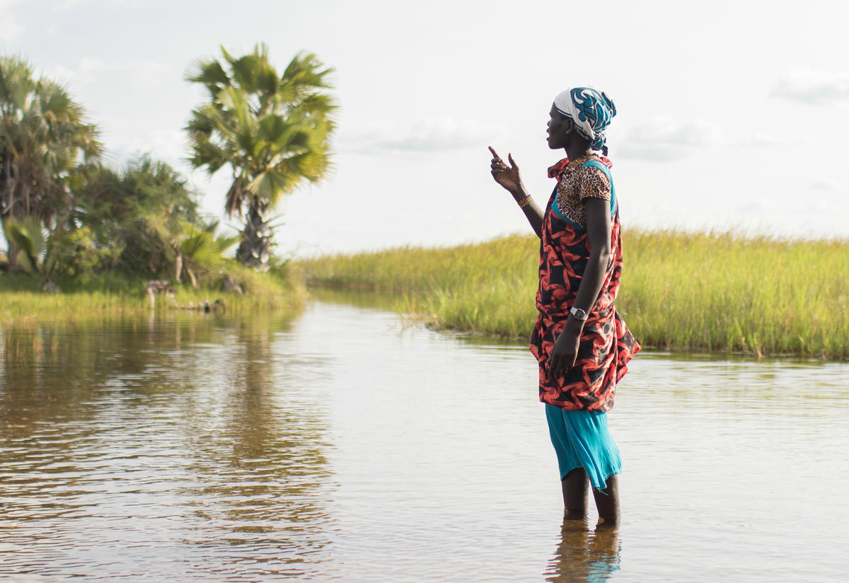 A woman stands in a swamp in Unity State, South Sudan
