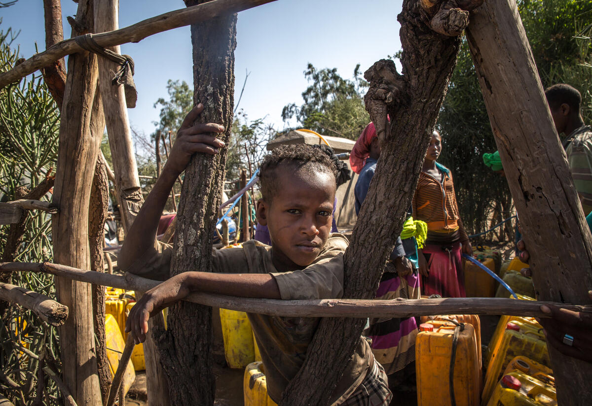 Aman Yassin, 12, waits at a water point to fill his jerrycans 