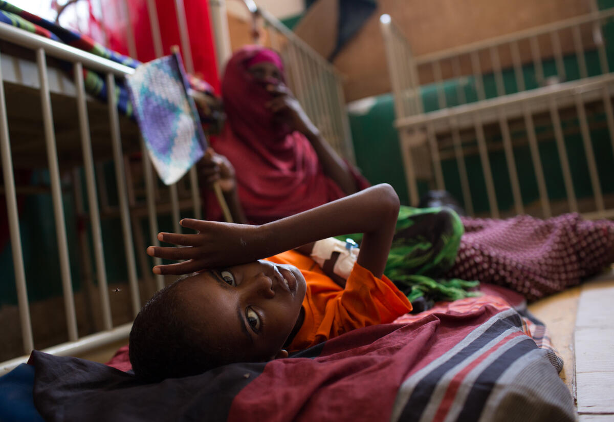 A young boy lies on a cot in the Mogadishu hospital where he is being treated for malnutrition 