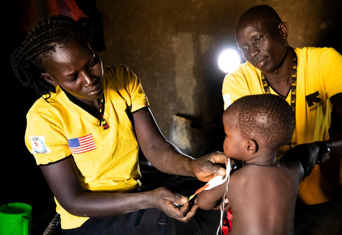 Health workers in South Sudan measure a toddler's arm for signs of malnutrition.