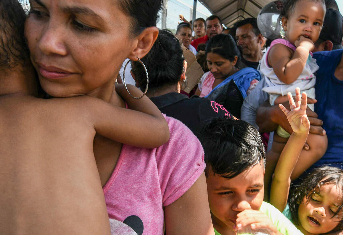 A Central American family waits to cross a border on their way to seek asylum in the U.S.