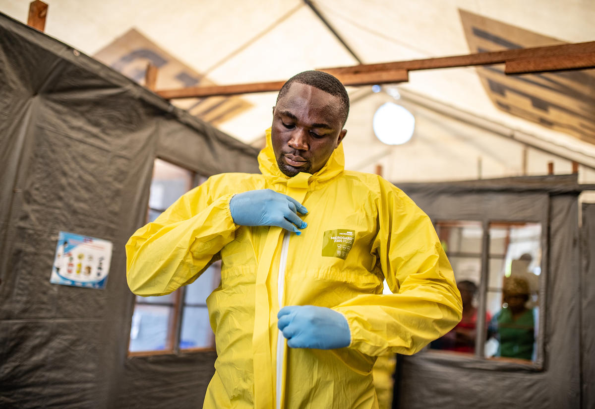 A health worker in the Democratic Republic of Congo puts on his jumpsuit and other protective gear to care for potential Ebola patients.
