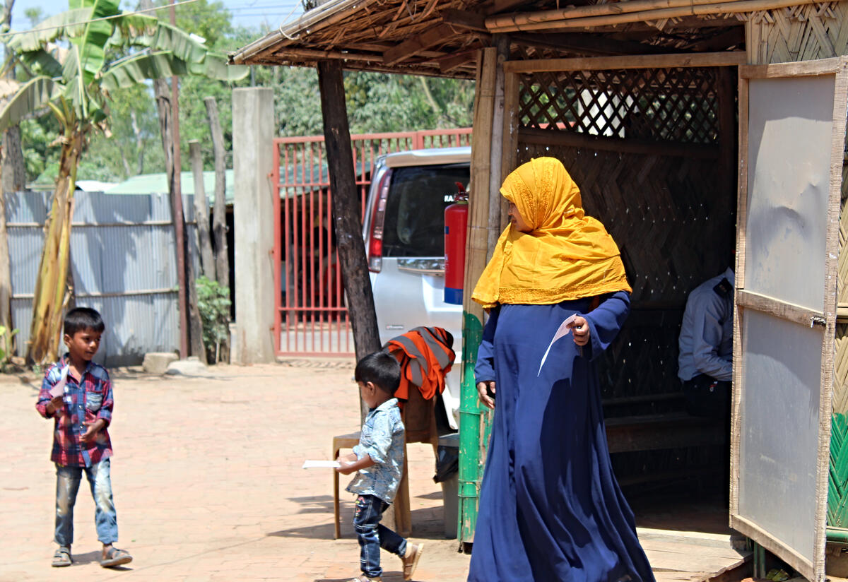 Sakera and her sons outside the outpatient area of the IRC primary health care center in Cox's Bazar