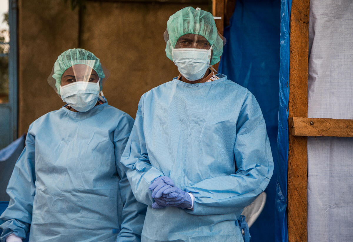 The International Rescue Committee continues to respond to both Ebola and COVID-19. Two health workers at an IRC-supported hospital who are responsible for screening patients for Ebola stand in their protective gear.