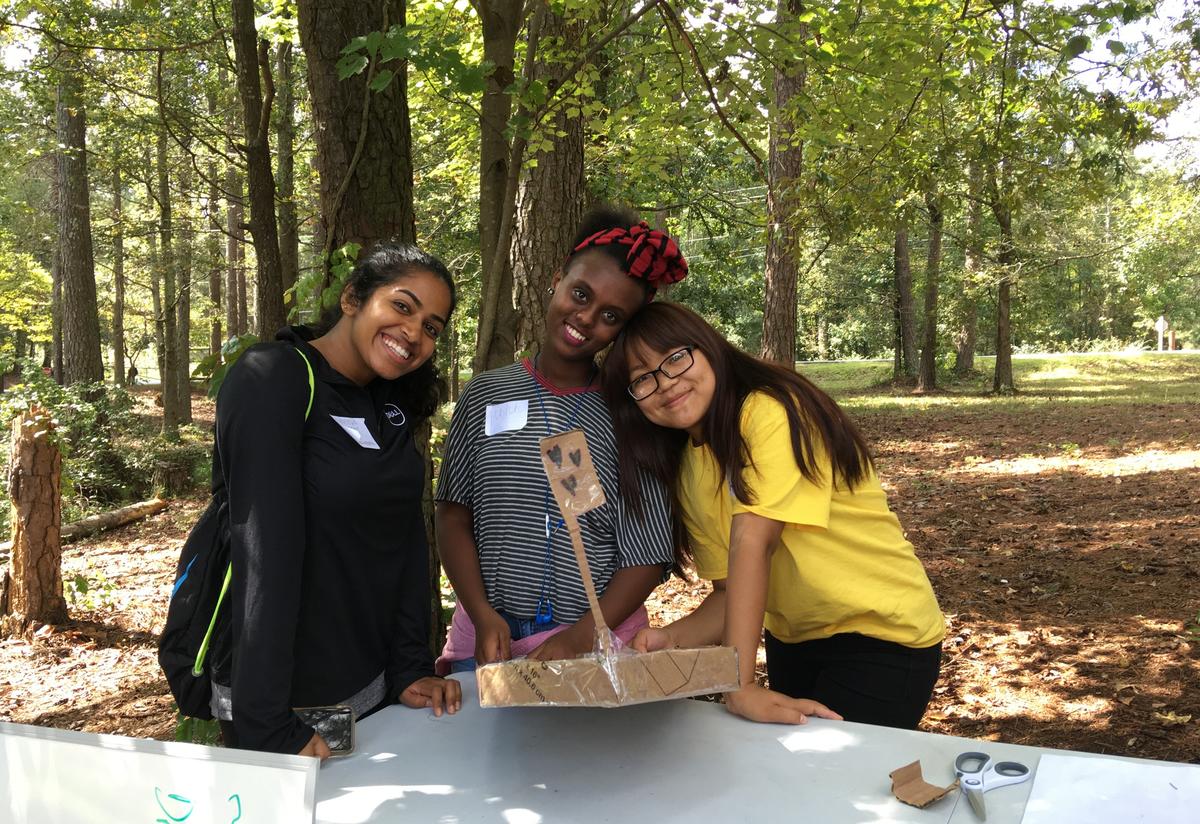 A Georgia Tech volunteer and Youth Futures students with their finished boat. 