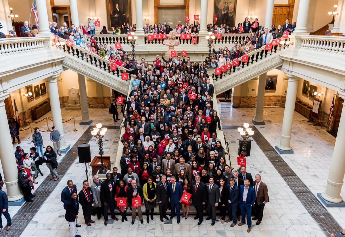 New Americans Celebration attendees gather for a photo with Governor Brian Kemp and Representatives. 