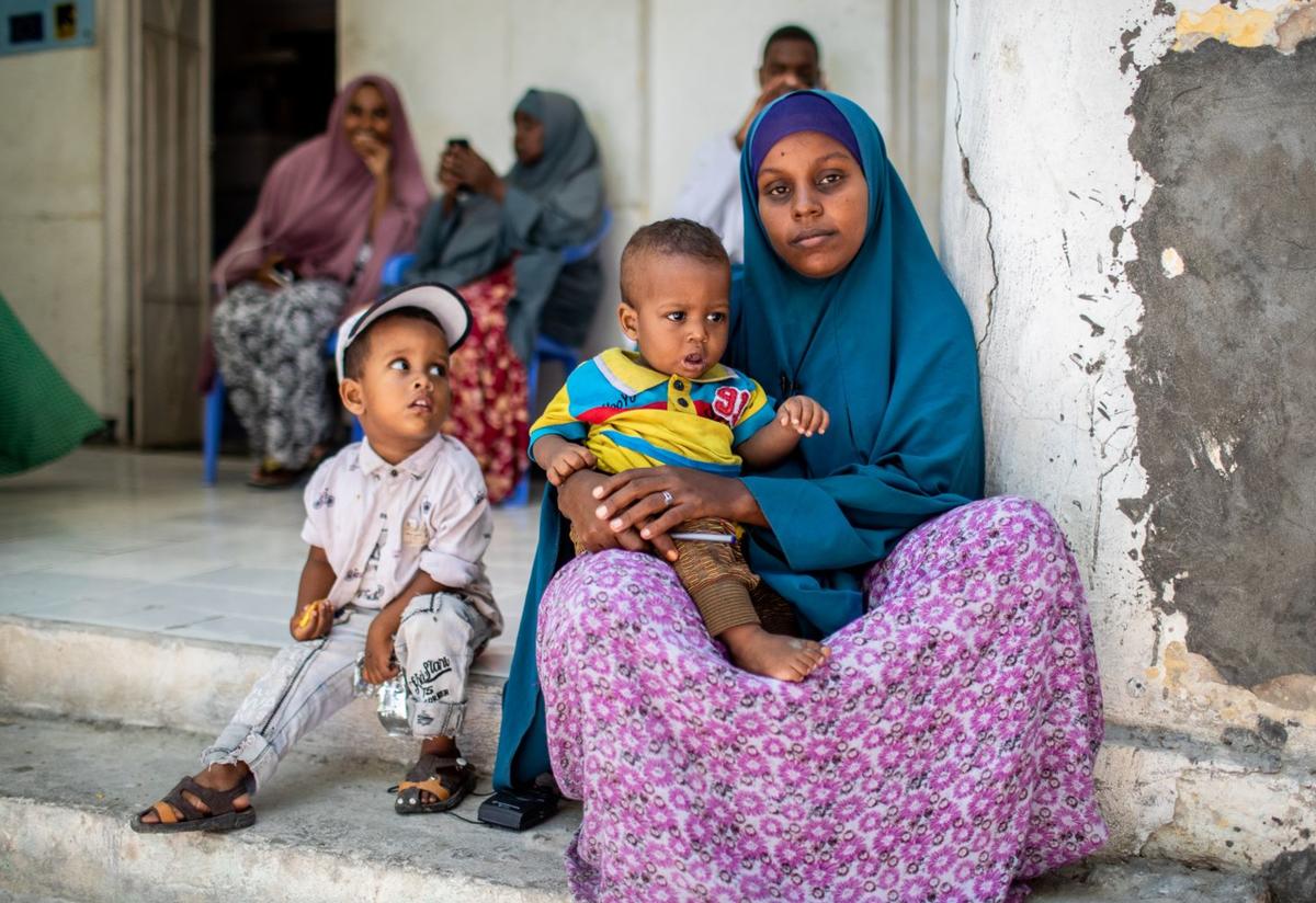 The International Rescue Committee is assisting displaced families, like this woman and her children, in Somalia. A displaced woman assisted by the IRC sits with her children in Somalia.