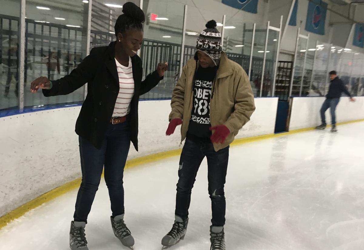 Two C2S students stand next to each other on the ice, carefully finding their balance.