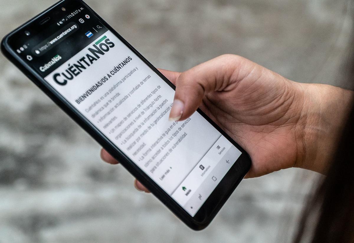 CuéntaNos is used to provide crucial information about COVID-19 to over 140 partners and all users who visit the site. CuéntaNos, an IRC platform, is shown on a phone in a neighborhood in San Salvador.
