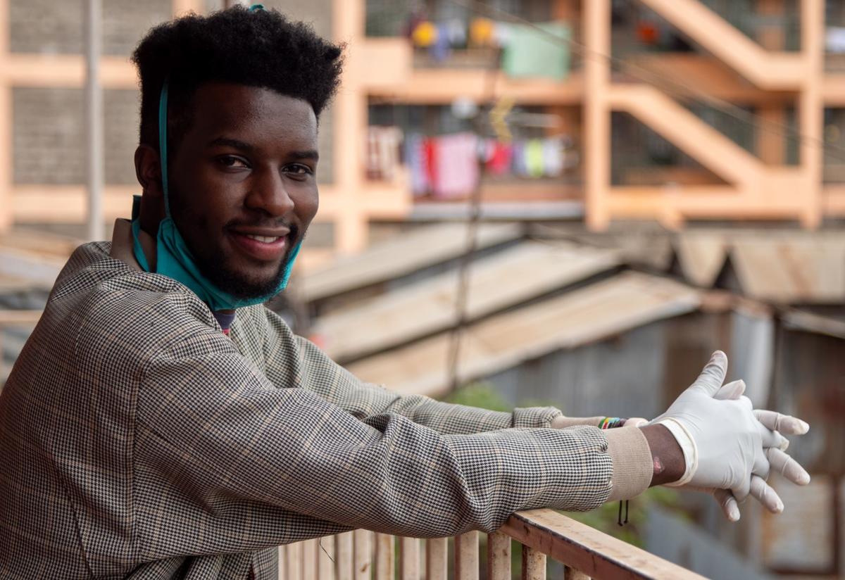 Jean Marie Ishimwe Jean Marie Ishimwe, a youth advocate and Rwandan refugee living in Kenya, leans against a railing with buildings behind him.