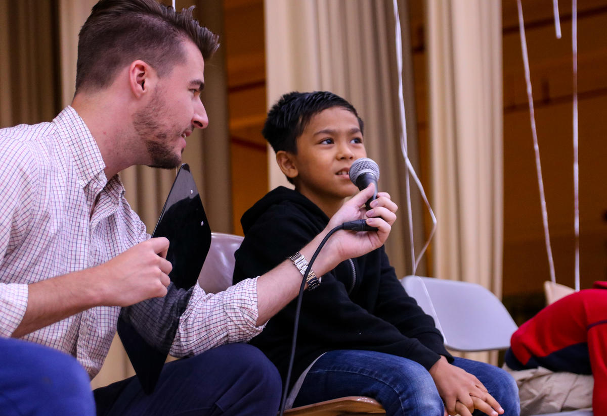 Youth Program Supervisor with RYSA student Youth Program Supervisor with RYSA student are talking in the auditorium.