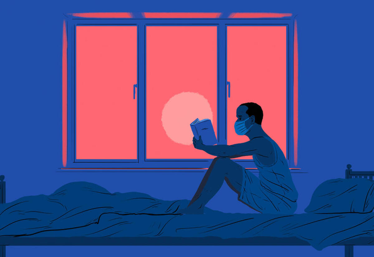 Victor in his home in Italy A man sits on a bed reading a book in front of a window.