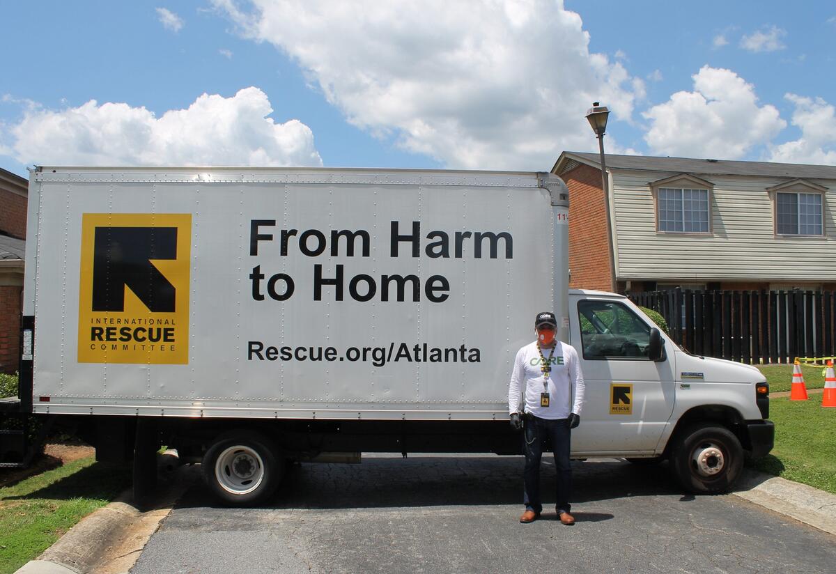The IRC’s Omar Aziz is managing the DeKalb testing project and working with the community to identify potential testers and interpreters. A man wearing an N-9 respirator mask and black medical gloves stands in front of a large truck with the IRC logo which reads "International Rescue Committee" and the phrase "From Harm to Home" on the side.