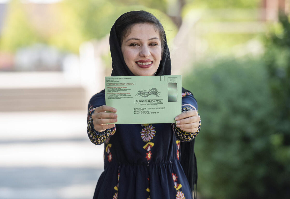 Muska Haseeb holds her ballot Muska Haseeb smiles and holds her mail-in ballot out to the camera