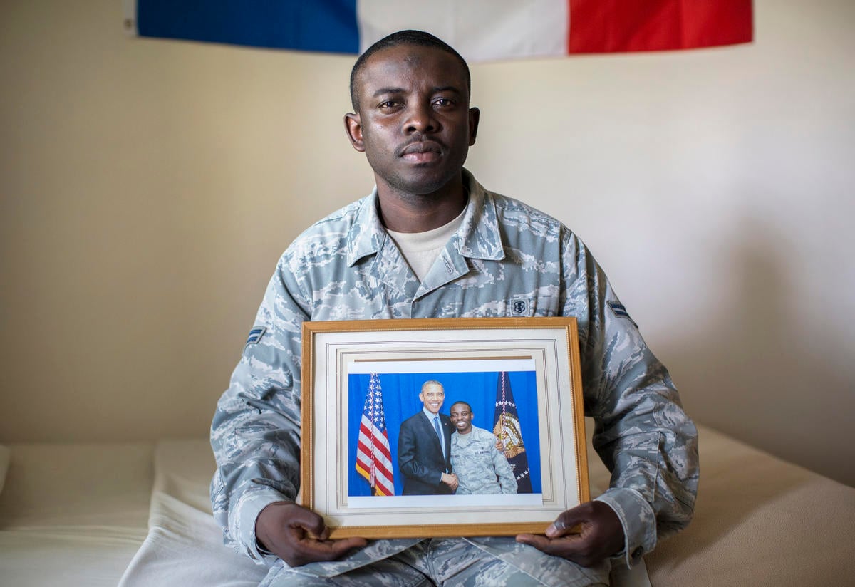 Nelson Rieu holds a photo of himself with Obama