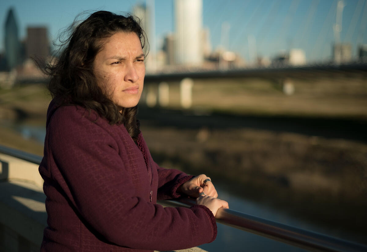 Valentina, a refugee from El Salvador Valentina, a refugee from El Salvador, stands on a bridge in Dallas, TX, and looks out over the water.